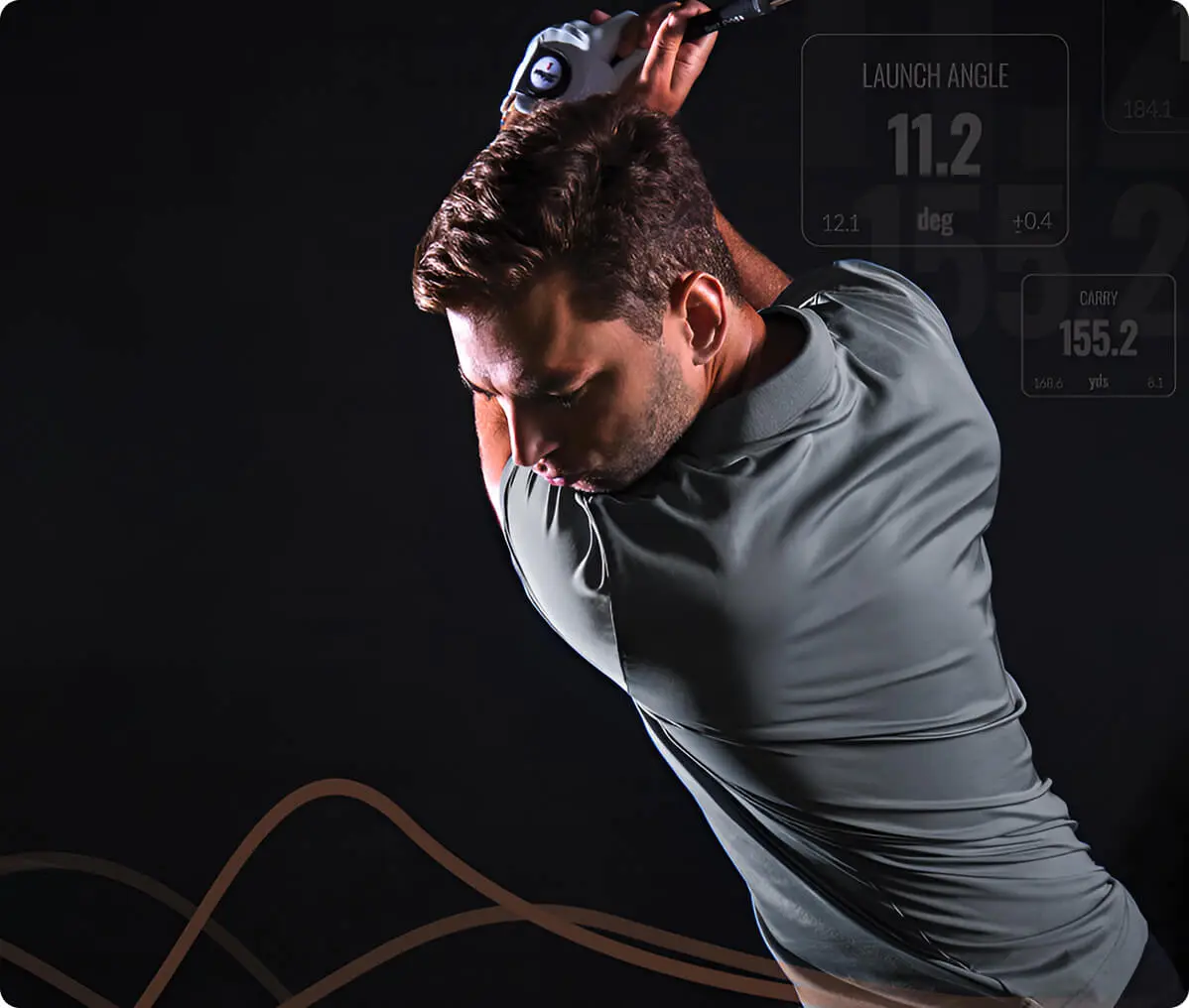 Man in mid-swing playing golf indoors